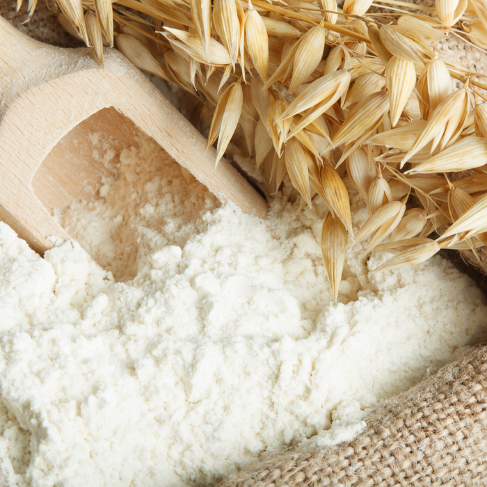Close-up of a wooden scoop filled with fine white rice flour surrounded by dried rice grains, representing Rice Flower Polish 50g | Privai for skincare and body care.