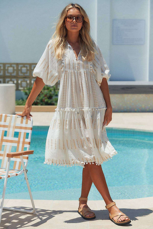 Seashell Palace Boho Midi Dress with button-front and pompom hem, styled for summer by the poolside. Features 3/4 balloon sleeves and tassel ties.