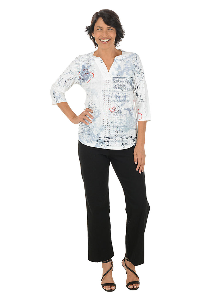 Woman wearing a white blouse with black patterns and black pants on a white background