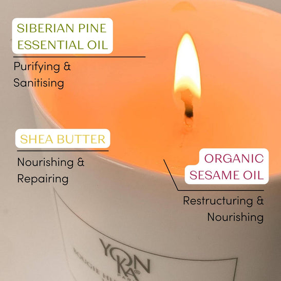 Close-up of a lit Taiga Massage Candle | Yon-Ka Paris highlighting its natural ingredients: Siberian pine essential oil for purifying, shea butter for nourishing, and organic sesame oil for restructuring and wellness.