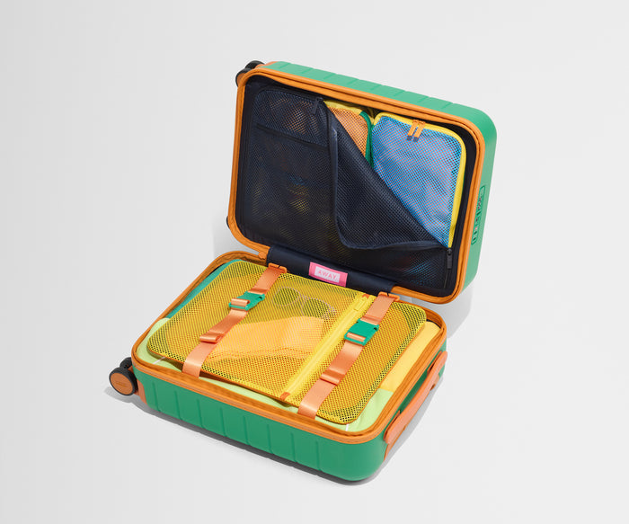 The Kids Carry-On suitcase in Froggy Green shown open on its side and packed with Away's packing organizers to show capacity and the interior compression system, designed to help you pack more in
// 
Our signature interior compression system allows you to stay more organized. Paired with the Kids Packing Cubes.