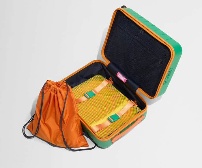 The Kids Carry-On suitcase in Froggy Green shown open and empty on its side to show capacity, and an orange laundry bag can double as a backpack for smaller travelers.
// 
Includes a drawstring laundry bag  that doubles as a backpack for smaller travelers.