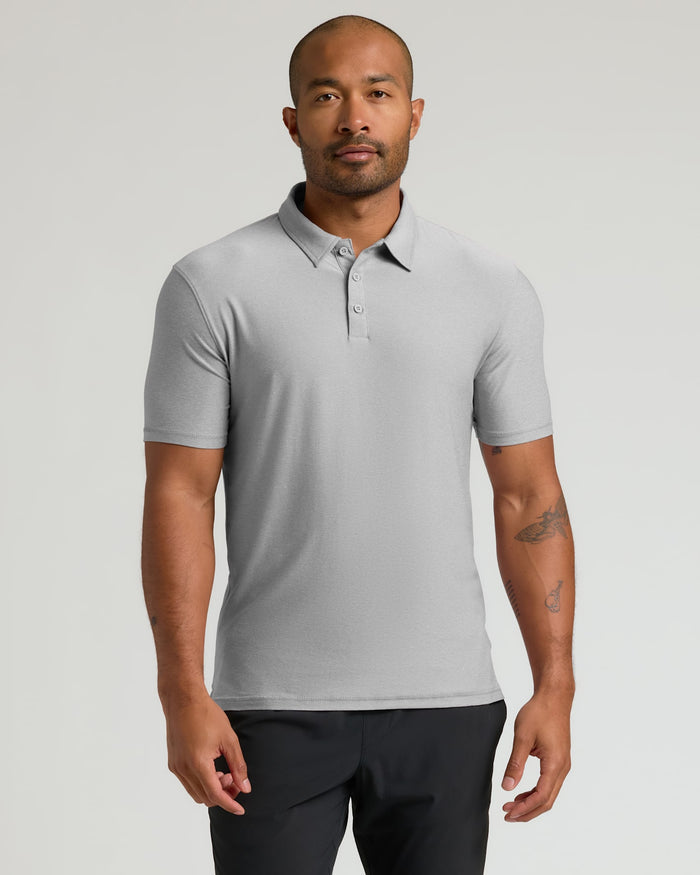 Man wearing a Light Heather Gray Active Polo 2.0 with short sleeves and a three-button placket, standing against a neutral background.