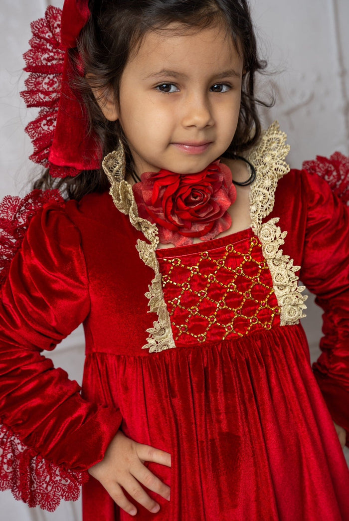 Child wearing Victoria red flower neck tie styled with a red velvet dress, featuring a bold fabric rose neckline for a classic holiday look