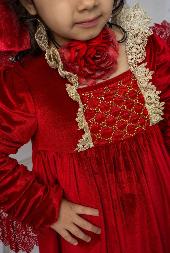 Close up of Victoria red flower neck tie highlighting textured layered fabric rose detail paired with a red velvet dress