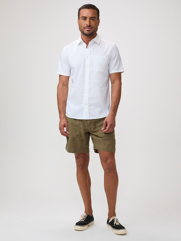 Man wearing a white short-sleeve shirt and green shorts | breathable button up shirts
